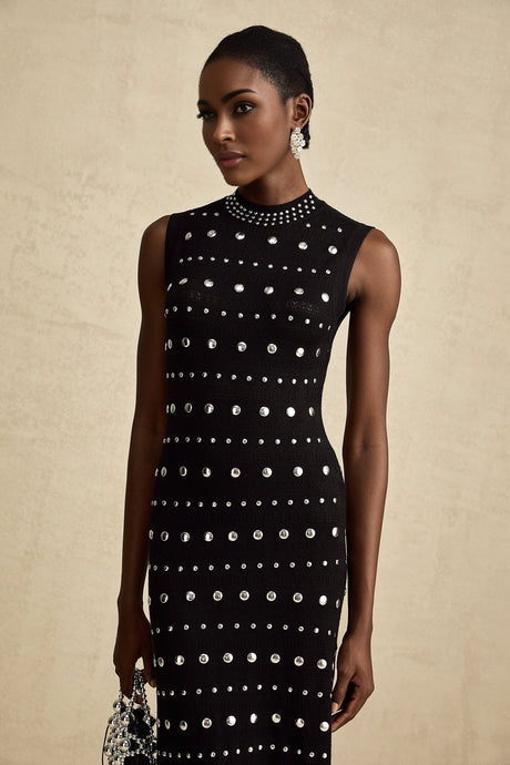 A black maxi dress with crochetknit pattern and studded details designed by Chloe featuring a long silhouette and intricate texture