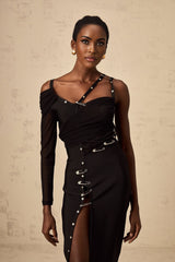 A black midi dress with an asymmetric hemline and cutout details worn by a model named Louise