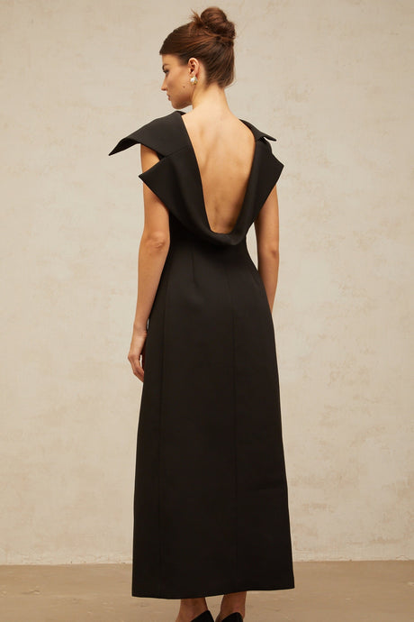 A black midi dress with an open back and deconstructed design featuring a sleek silhouette and elegant style