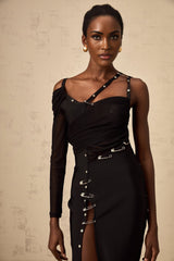 A black midi dress with asymmetric design and cutout details worn by a model against a plain background