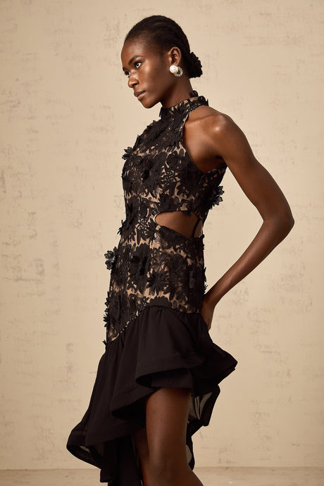 A black midi dress with asymmetric hemline featuring colorful floral applique detailing