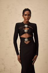 A black midi dress with cutout details featuring a sun motif design and ruched fabric Named Astrid the dress has a sleek silhouette with strategic openings