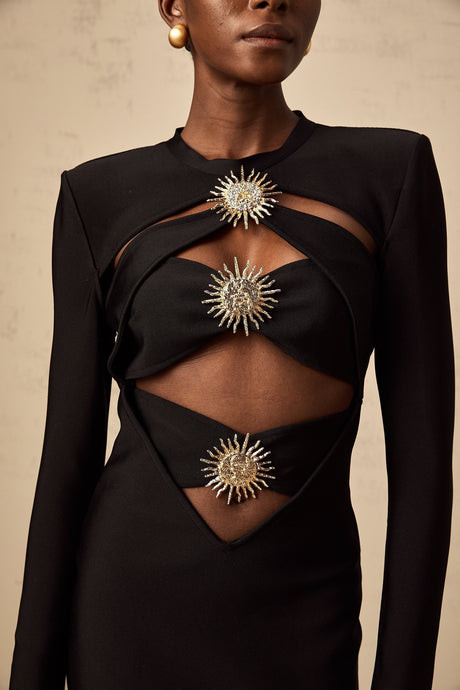 A black midi dress with cutout details featuring a sun motif pattern and ruched design named Astrid