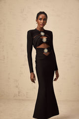 A black midi dress with cutout details featuring a sun motif pattern and ruched fabric Astrid style with a formfitting silhouette