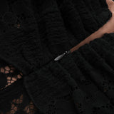 A black midi dress with floral lace detailing and flared cuffs named Émeline shown on a model or mannequin against a plain background