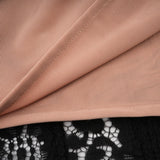 A black midi dress with floral lace detailing and flared cuffs named Émeline