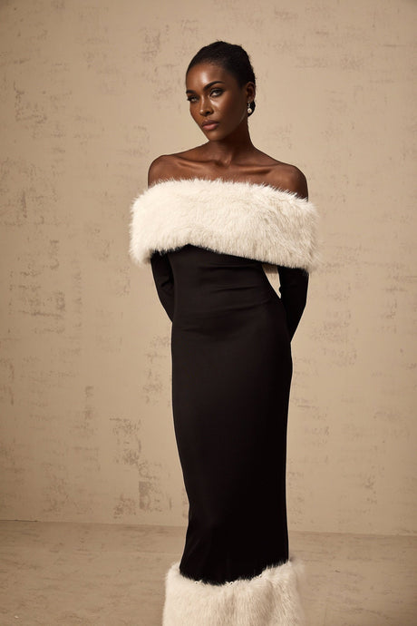A black midi dress with offshoulder design and faux fur trim worn by a model against a plain background