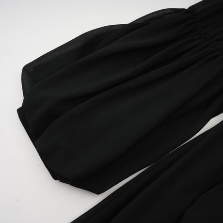 A black midi dress with pleated details and buttons down the front named Viviane
