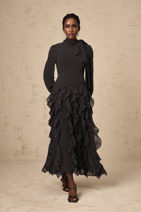A black midi dress with white polka dots and ruffled details featuring a fitted bodice and flared skirt