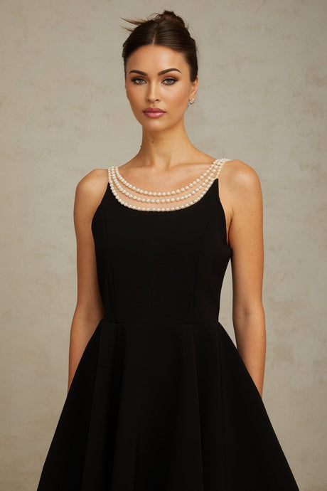 A black mini dress adorned with faux pearl embellishments called Danae