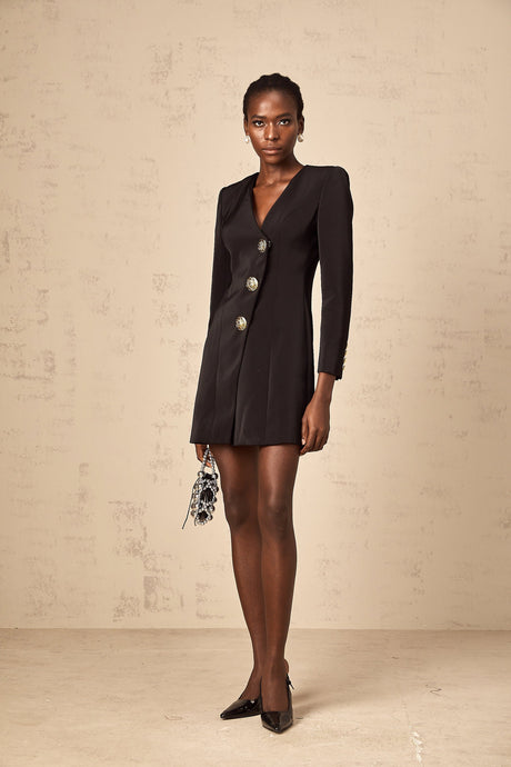 A black mini dress with a blazer style featuring lion head details and a short hemline