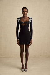 A black mini dress with a bustier top covered in shiny sequins and a fitted silhouette