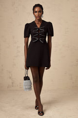 A black mini dress with a decorative bowknot detail