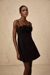 A black mini dress with a flared skirt featuring delicate rose appliqués and a fitted bodice