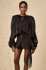 A black mini dress with a fully pleated design and ruffled details featuring a short hemline and feminine silhouette