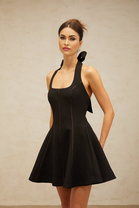 A black mini dress with a halterneck design featuring a bow detail at the neckline