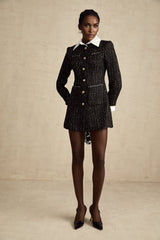 A black mini dress with a tweed base and sequin panels featuring a sleeveless design and a fitted silhouette named Audrey