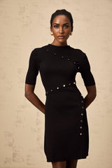 A black mini dress with fine knit texture featuring decorative buttons and a short hemline modeled on a female figure
