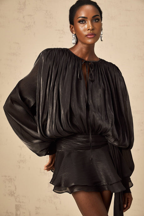 A black mini dress with full pleats and ruffles named Eugenie featuring a short hemline and feminine details
