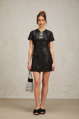 A black mini dress with glitter details and a short hemline