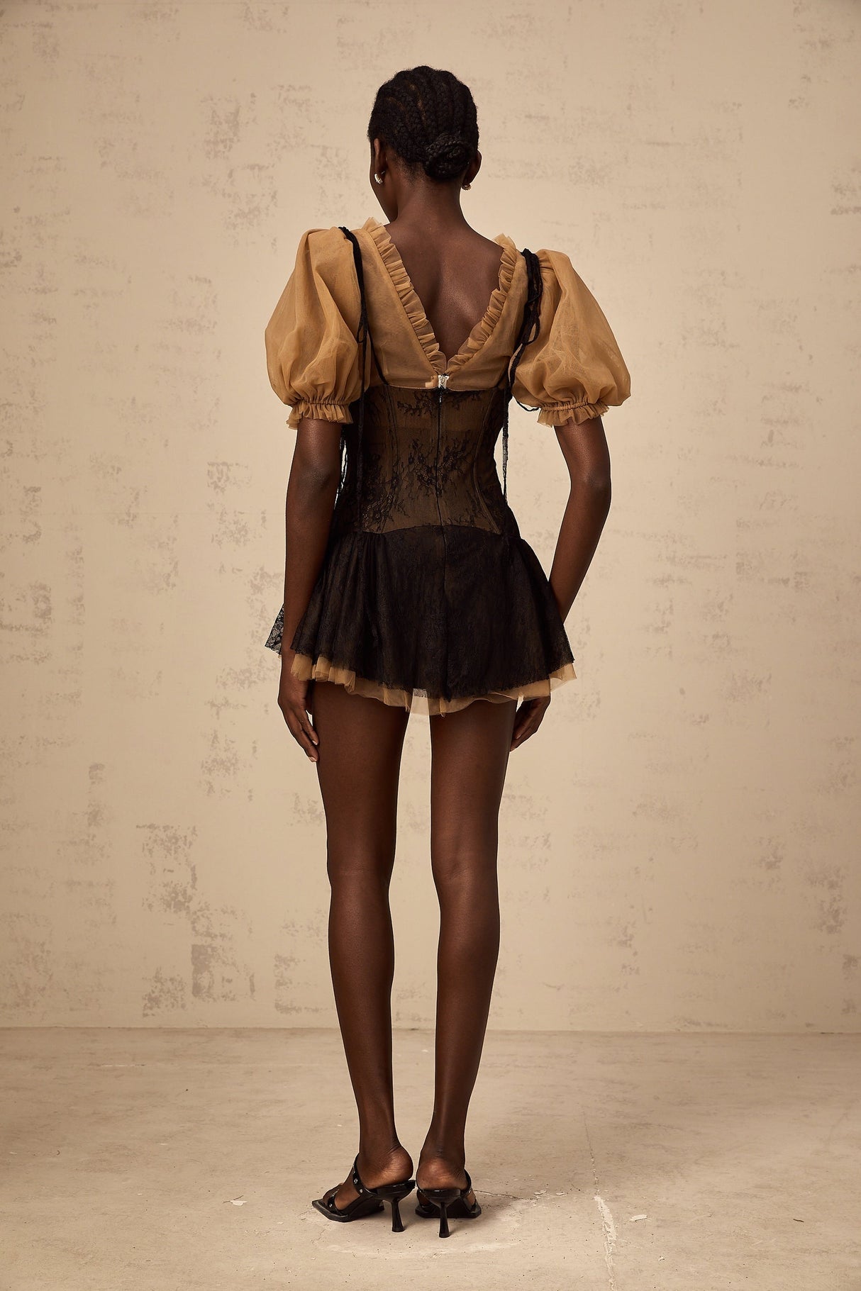 A black mini dress with lace panelling details and a fitted silhouette