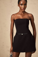 A black mini dress with puffed sleeves and a prominent bowknot detail named Clothilde