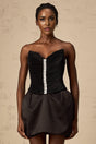 A black mini dress with ruched detailing and puff sleeves named Francis