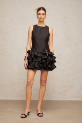 A black mini dress with ruffled tiers and a short hemline featuring a feminine silhouette and delicate details