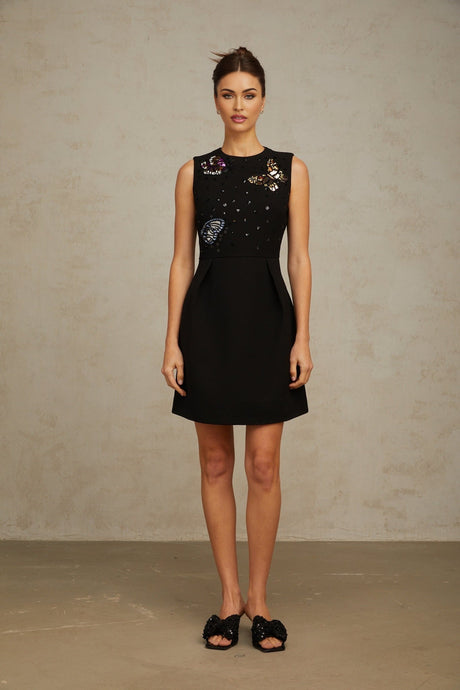 A black mini dress with sequin embellishments featuring a butterfly design Manon style short and fitted silhouette