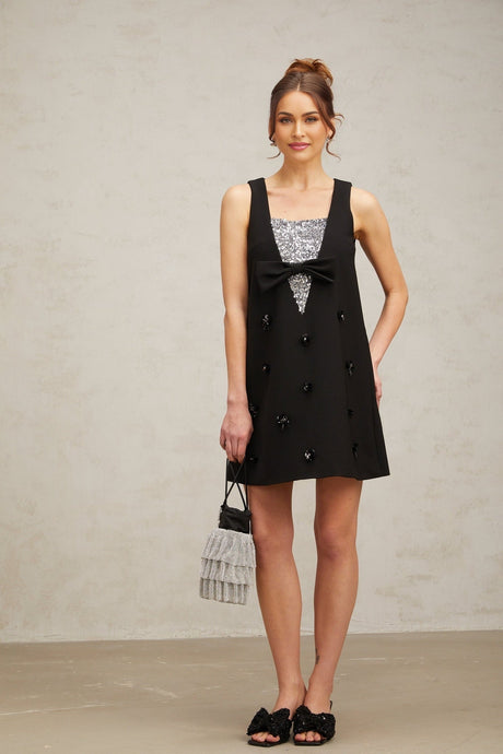A black mini dress with shimmering 3d floral sequin details covering the fabric creating a textured petal effect