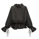 A black mini dress with tiered layers and floral applique details called Zephyrine