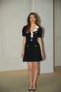 A black mini dress with waffle knit texture and embellishments named Ava featuring a short length and decorative details
