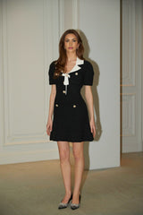 A black mini dress with waffleknit texture featuring embellishments named Ava worn by a model standing against a plain background
