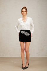 A black mini skirt with feather embroidery and embellishments called Myriam