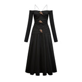 A black offshoulder maxi dress with panelled design featuring a long flowing skirt and fitted bodice worn by a model