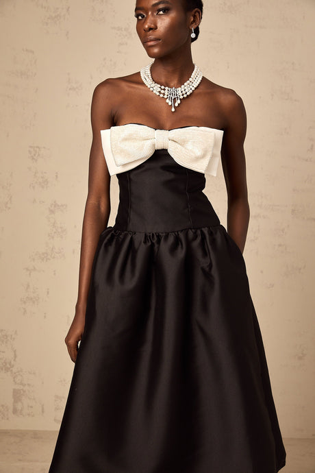 A black offshoulder midi dress made of georgette fabric featuring a bowknot detail