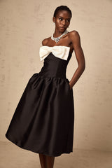 A black offshoulder midi dress made of georgette fabric featuring a bowknot detail