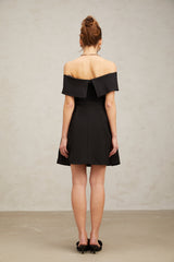 A black offshoulder mini dress with a belt featuring a fitted silhouette and short length named Greta