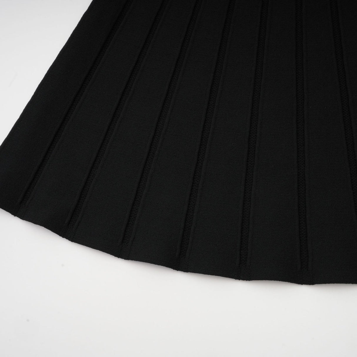 A black offshoulder mini dress with a bow detail and knit fabric worn by a model