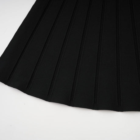 A black offshoulder mini dress with a bow detail and knit fabric worn by a model