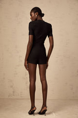 A black playsuit featuring embossed buttons named Solene worn by a model against a plain background