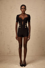 A black playsuit featuring embossed buttons named Solene worn by a model against a plain background