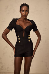 A black playsuit with embossed buttons featuring the Solene brand name