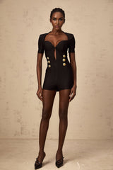 A black playsuit with embossed buttons named Solene featuring a short design with a fitted silhouette and decorative button details