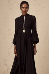 A black pleated midi dress with a button front closure and the name Viviane