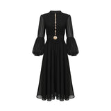 A black pleated midi dress with a buttonfront design featuring long sleeves and a flowing silhouette