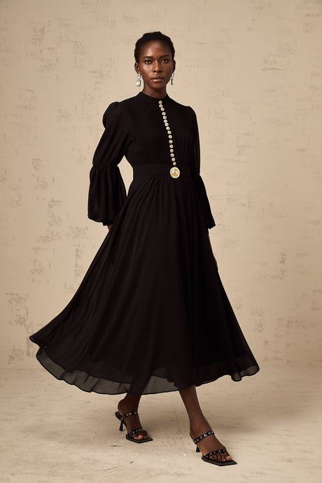 A black pleated midi dress with a buttonfront design featuring long sleeves and a flowy silhouette named Viviane
