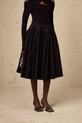 A black pleated midi skirt with a flared silhouette named Pauline