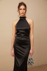 A black satin maxi dress with a halterneck style featuring faux pearl embellishments