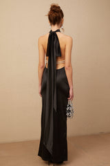 A black satin maxi dress with a halterneck style featuring faux pearl embellishments